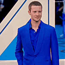 a man in a blue suit is standing in front of a sign that says joequinncraves