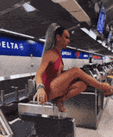 a woman in a red dress sits on a delta sign