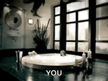 a person is jumping into a bathtub in a bathroom with the words `` you '' written on the bottom .
