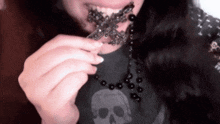a woman is wearing a cross necklace and a skull shirt