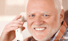 a man with a beard is smiling and talking on a phone