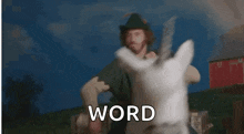 a woman is riding on the back of a white reindeer with the word word behind her .