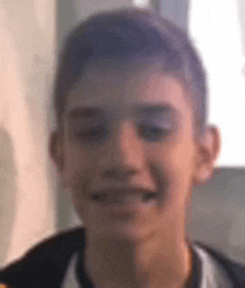 a young boy is smiling in a blurry photo .