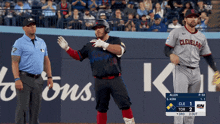 a baseball player wearing a cleveland jersey stands next to a referee