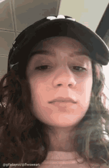 a close up of a woman 's face wearing a baseball cap