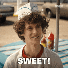 a man with curly hair is smiling with the word sweet above him