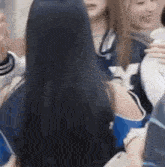 a group of women are sitting around a table talking to each other .