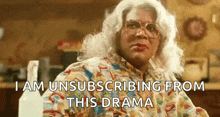 a woman in a wig and glasses is saying i am unsubscribing from this drama