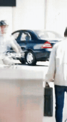 a blurry picture of a man walking with a briefcase and a car in the background