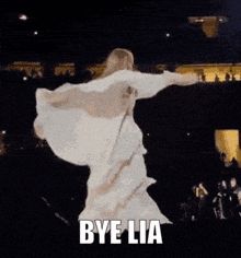 a woman in a white dress with wings is dancing with the words bye lia above her