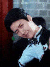 a man wearing a tuxedo and white gloves is making a face
