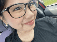a woman wearing glasses and a nose ring is smiling