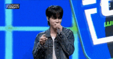 a young man is singing into a microphone on stage .