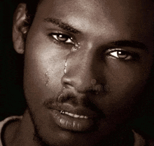a black and white photo of a man with tears running down his face
