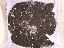 a pile of dirt with white spots on it in a white bag