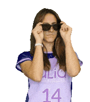 a woman wearing sunglasses and a purple shirt with the number 14