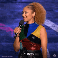 a woman holding a microphone and saying cunty