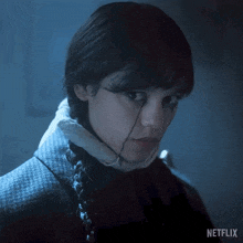 a close up of a woman 's face with a netflix logo in the background