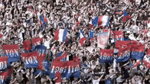 a crowd of people holding flags with one that says 1982 on it