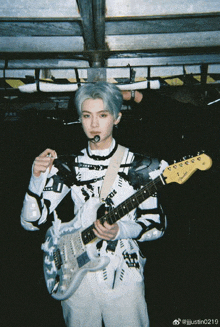 a person holding a fender guitar and a microphone