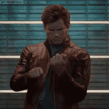 a man in a leather jacket is standing in front of a brick wall with gif-finder.com written on the bottom right