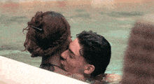 a man and a woman kissing in a swimming pool