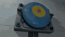 a blue object with a yellow circle on it is sitting on a metal surface