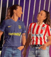 two women are standing next to each other wearing shirts that say herbalife