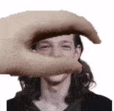 a hand is covering a man 's face in a pixelated photo