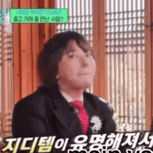 a man in a suit and tie is making a funny face in korean .