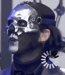 a man wearing a silver mask with a skull on his face
