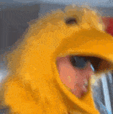 a man is wearing a yellow chicken costume and sunglasses
