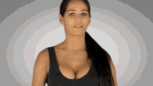 a woman with a ponytail is wearing a black tank top with a large breast .