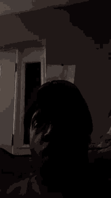 a person 's head is visible in the dark in front of a white door