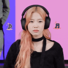 a woman wearing headphones and a choker looks at the camera with a pink background