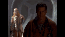 a man wearing a nasa jacket looks at the camera