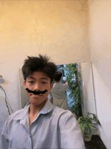a young man taking a selfie with a fake mustache