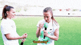 two women are standing on a field and one of them is wearing a shirt that says beatboxing