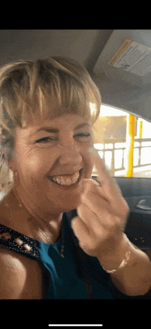 a woman in a blue shirt is giving the middle finger
