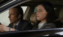 a man and a woman are sitting in a car