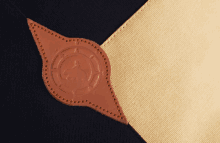 a close up of a piece of cloth with a brown leather emblem on it
