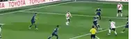 a group of soccer players are playing on a field with a toyota banner behind them