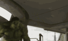 a hulk is running through a building with a tower in the background