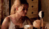 a woman is sitting in front of a mirror looking at herself in the mirror .