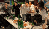 a group of people are standing around a table with bottles of water