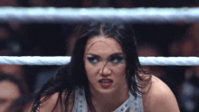 a woman in a wrestling ring with the word wwe on the bottom right