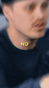 a close up of a man 's face with the word no written on it