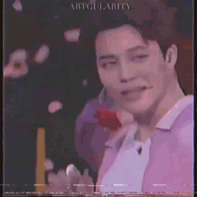 a man in a purple shirt is holding a red rose in his mouth .