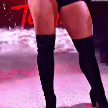 a woman wearing black over the knee boots is standing on a carpet
