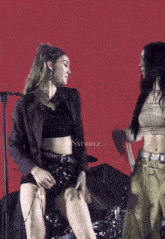 two women are dancing on a stage in front of a screen that says @sxrinz